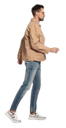 Man in stylish outfit walking on white background