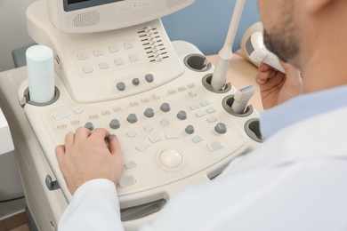 Sonographer operating modern ultrasound machine in clinic, closeup