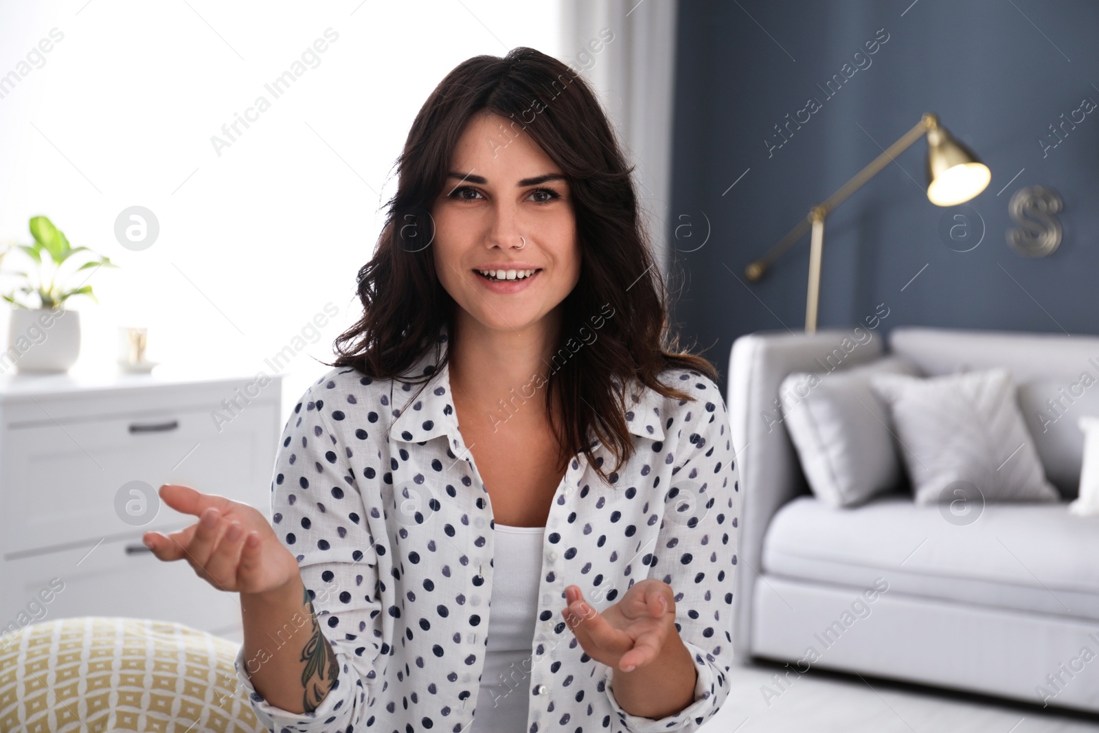 Photo of Young woman talking to her coworkers through video conference indoors, view from webcam