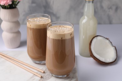 Delicious coffee with coconut syrup on white table