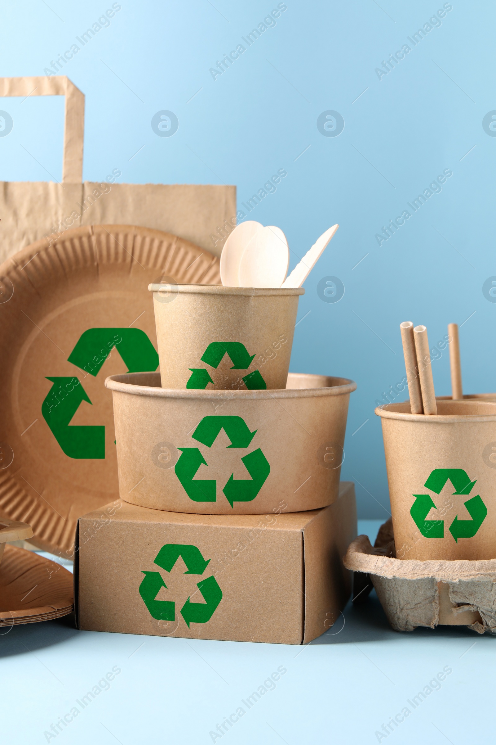 Image of Set of eco friendly food packaging with recycling symbols on light blue background