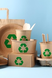 Image of Set of eco friendly food packaging with recycling symbols on light blue background