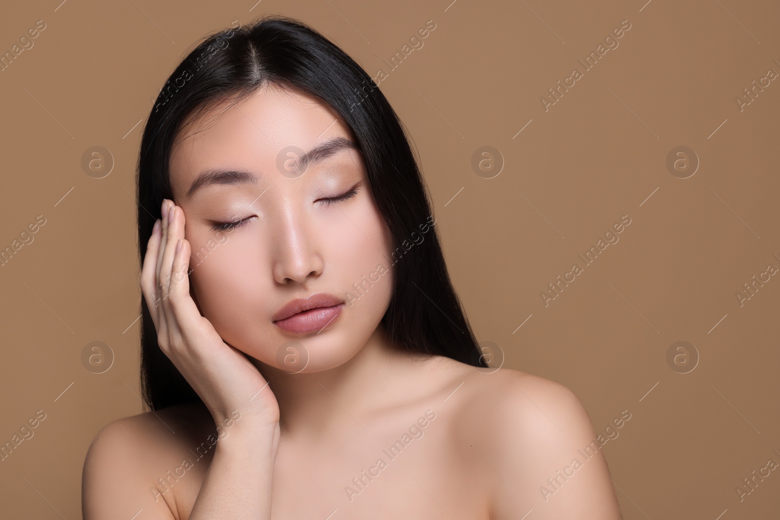 Photo of Portrait of beautiful young Asian woman on beige background, space for text