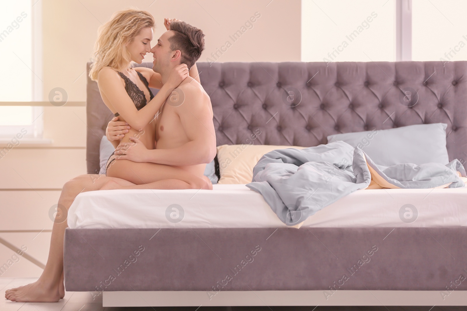 Photo of Sexy young couple being intimate on bed at home