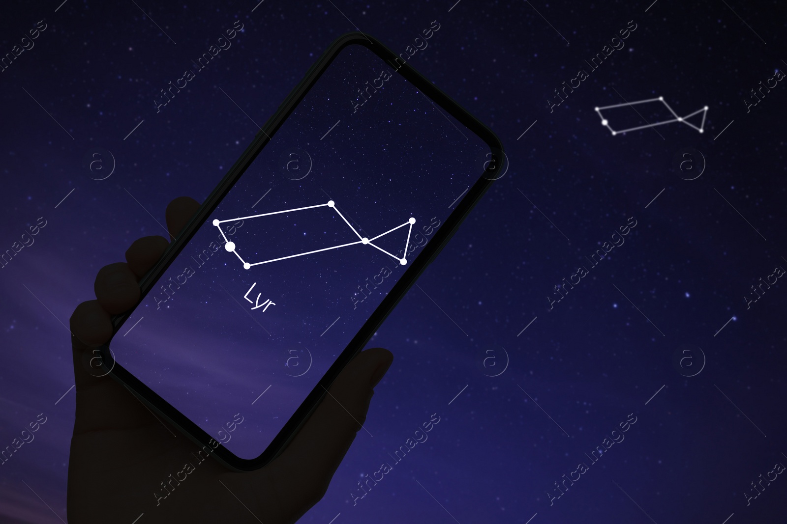 Image of Woman using stargazing app on her phone at night, closeup. Identified stick figure pattern of Lyra constellation on device screen
