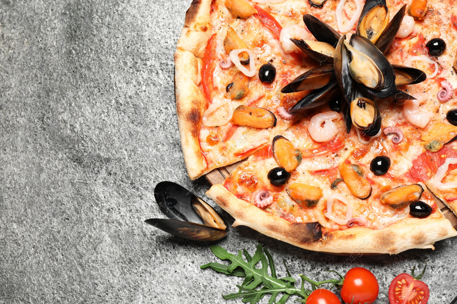 Photo of Tasty pizza with seafood and ingredients on grey table, flat lay