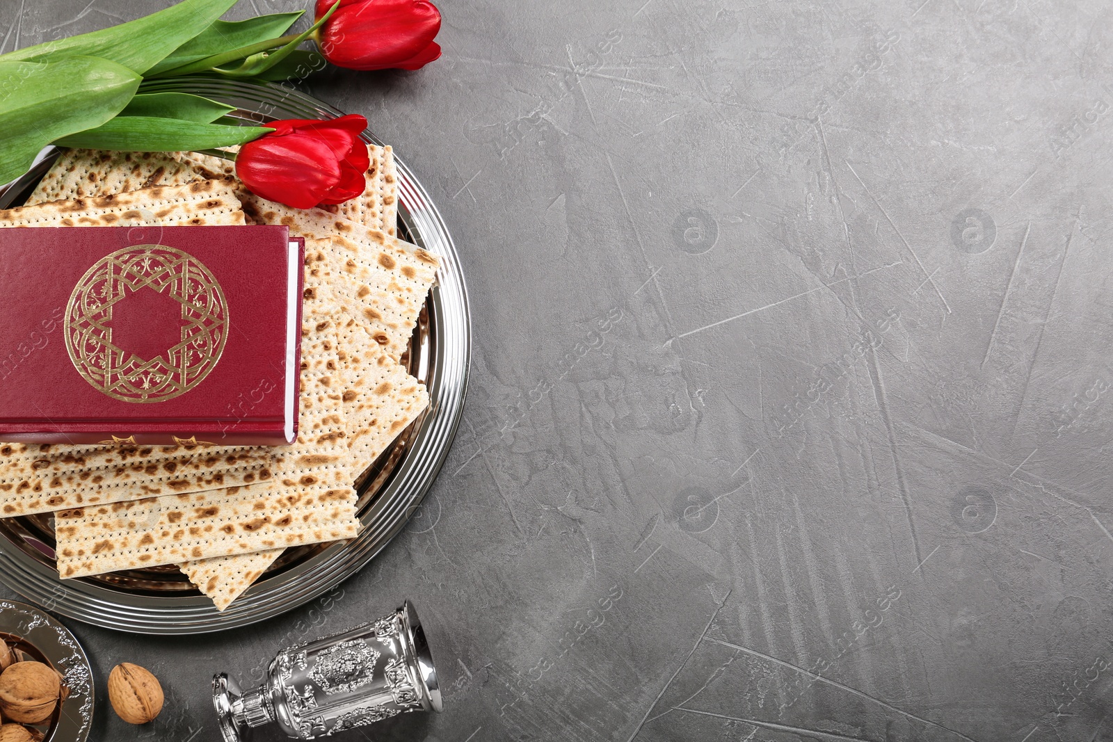 Photo of Flat lay composition with traditional Pesach (Passover Seder) items on grey table. Space for text