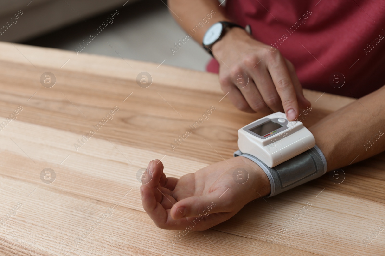 Photo of Man checking blood pressure at table indoors, closeup with space for text. Cardiology concept