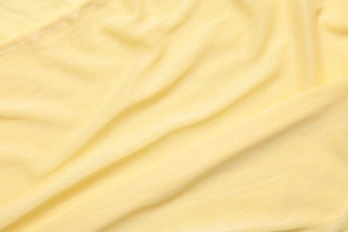 Photo of Texture of soft yellow crumpled fabric as background, top view