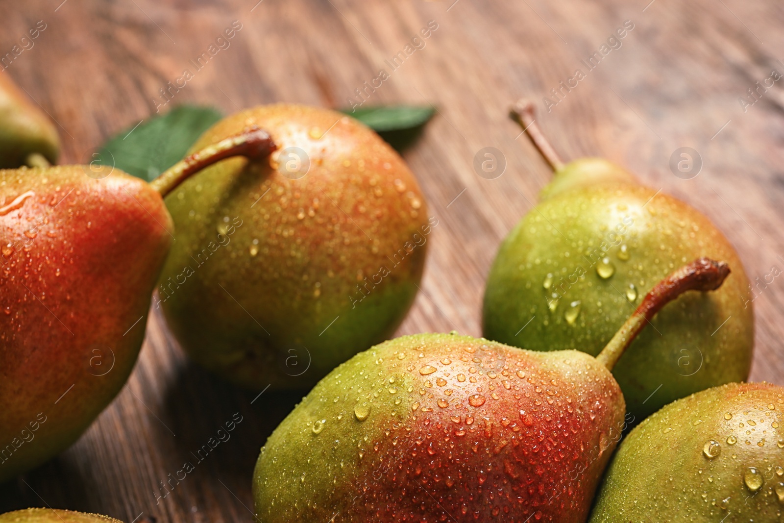 Photo of Tasty ripe pears on wooden table, closeup