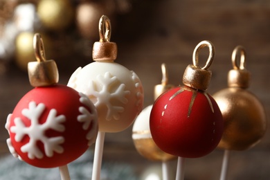 Photo of Delicious Christmas ball cake pops on blurred background, closeup