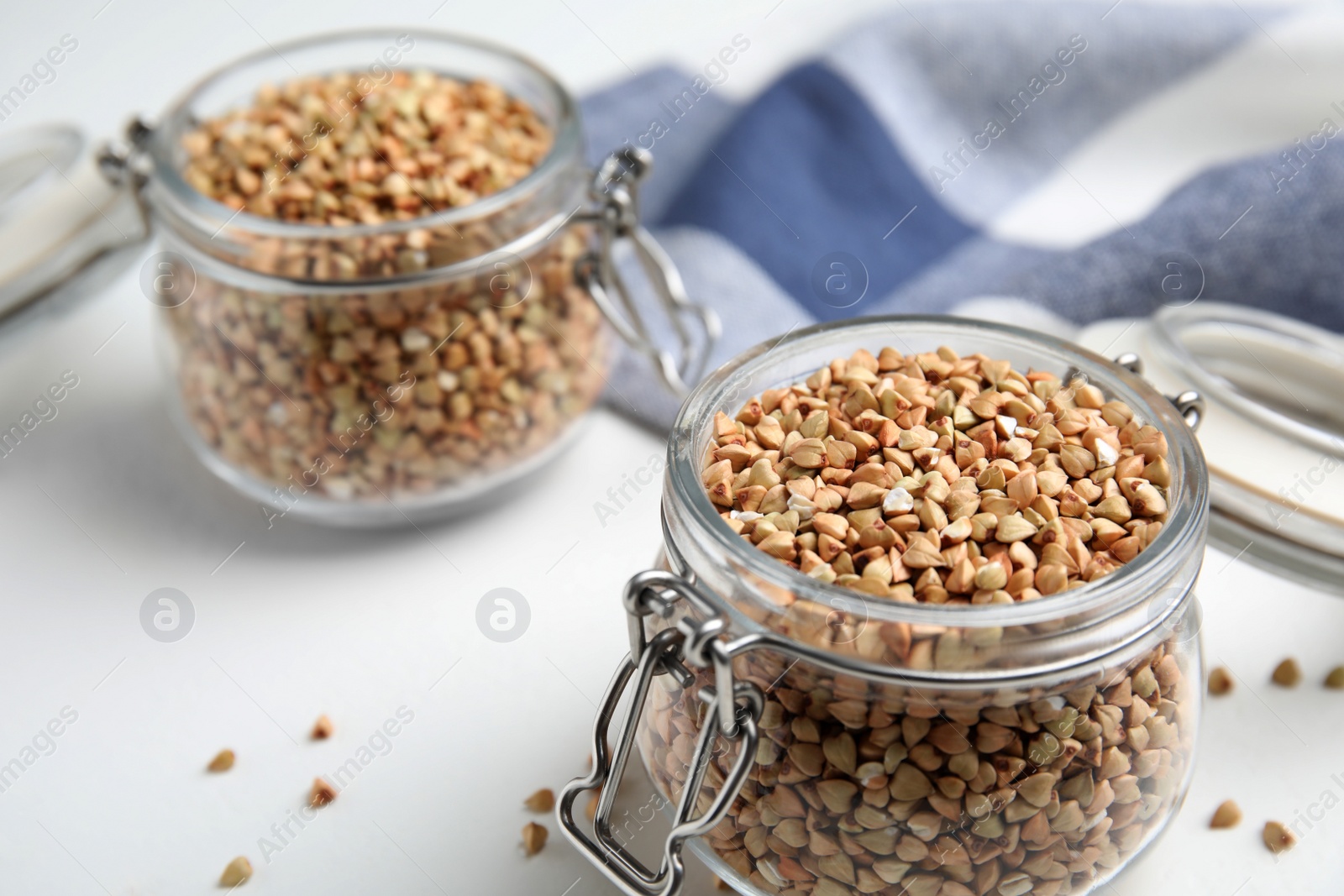 Photo of Jars with green buckwheat on white table