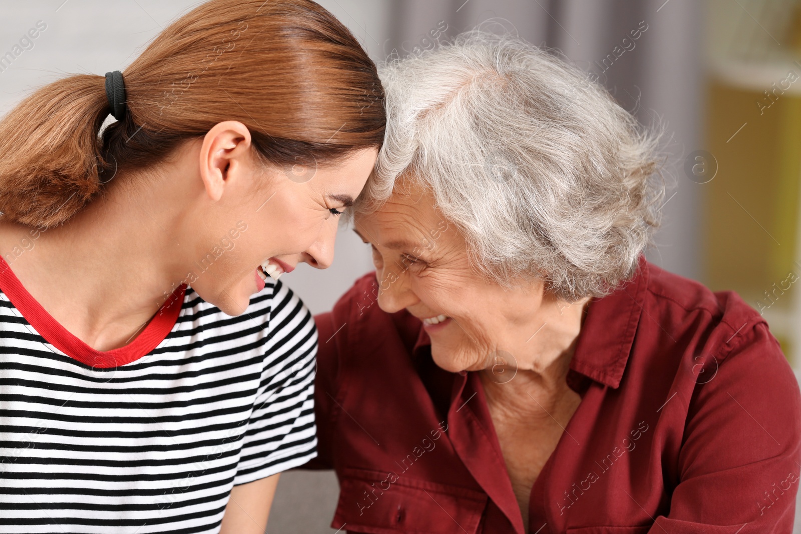 Photo of Elderly woman with female caregiver on blurred background