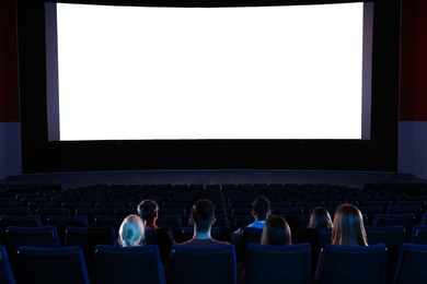 Photo of Young people watching movie in cinema theatre. Space for text