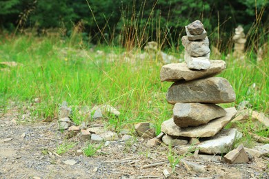Photo of Many stacked stones on green grass outdoors, space for text