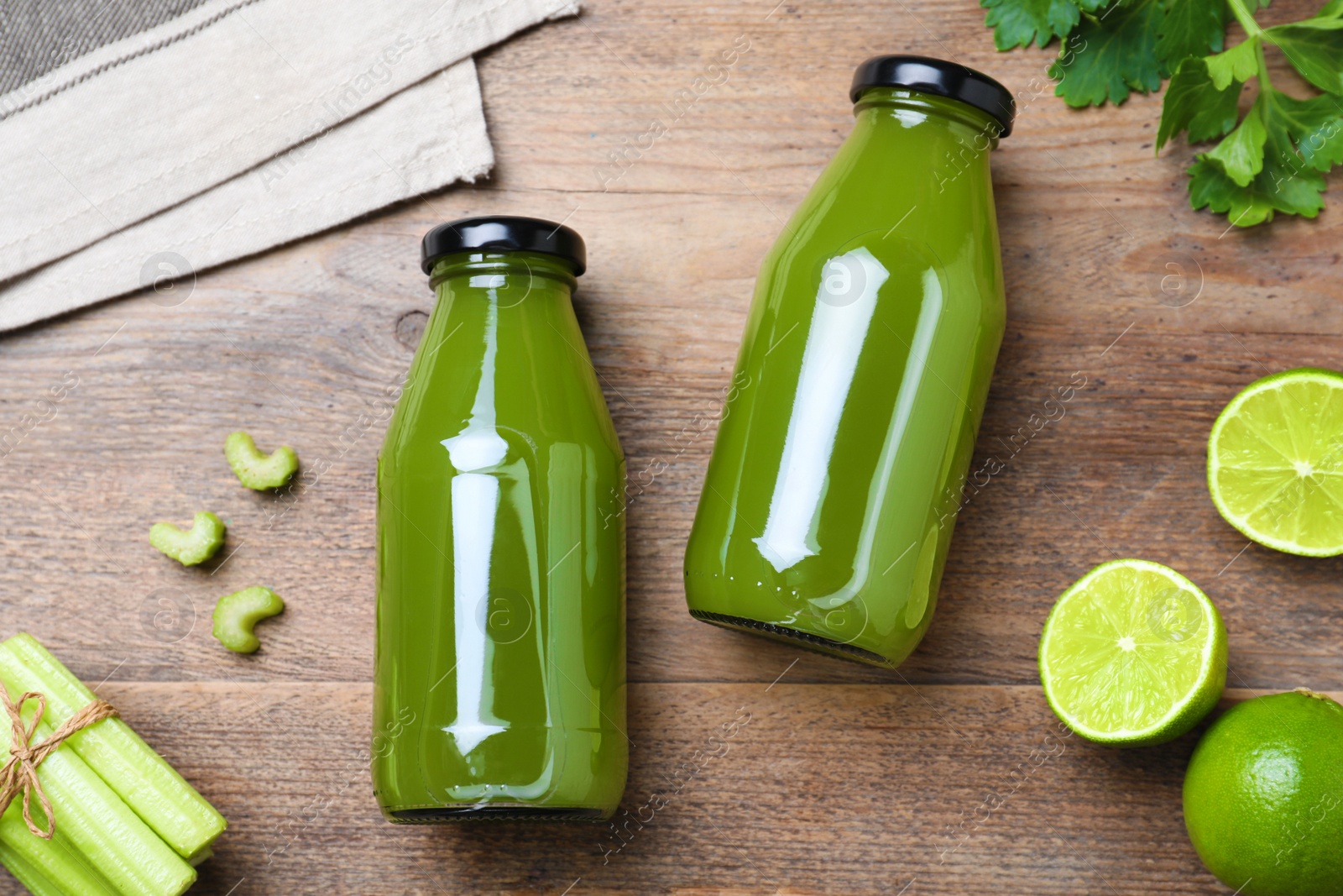 Photo of Bottles with celery juice and fresh ingredients on wooden table, flat lay