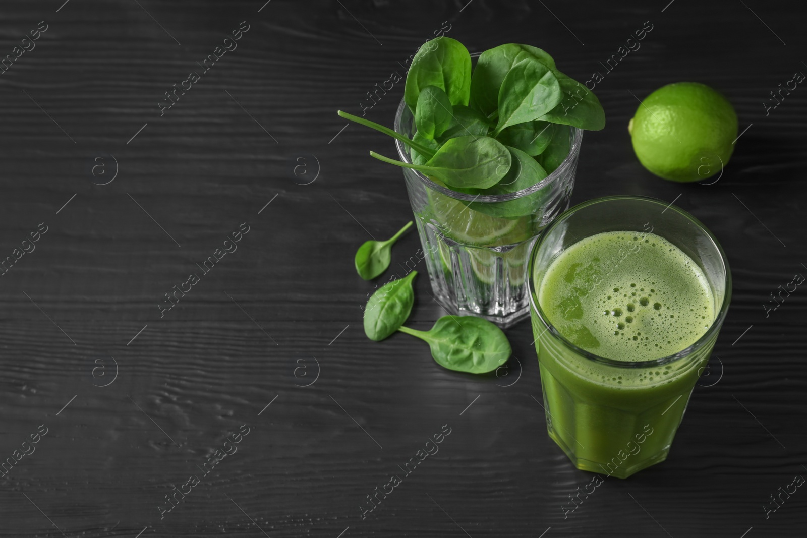 Photo of Glasses with delicious detox juice and ingredients on dark background