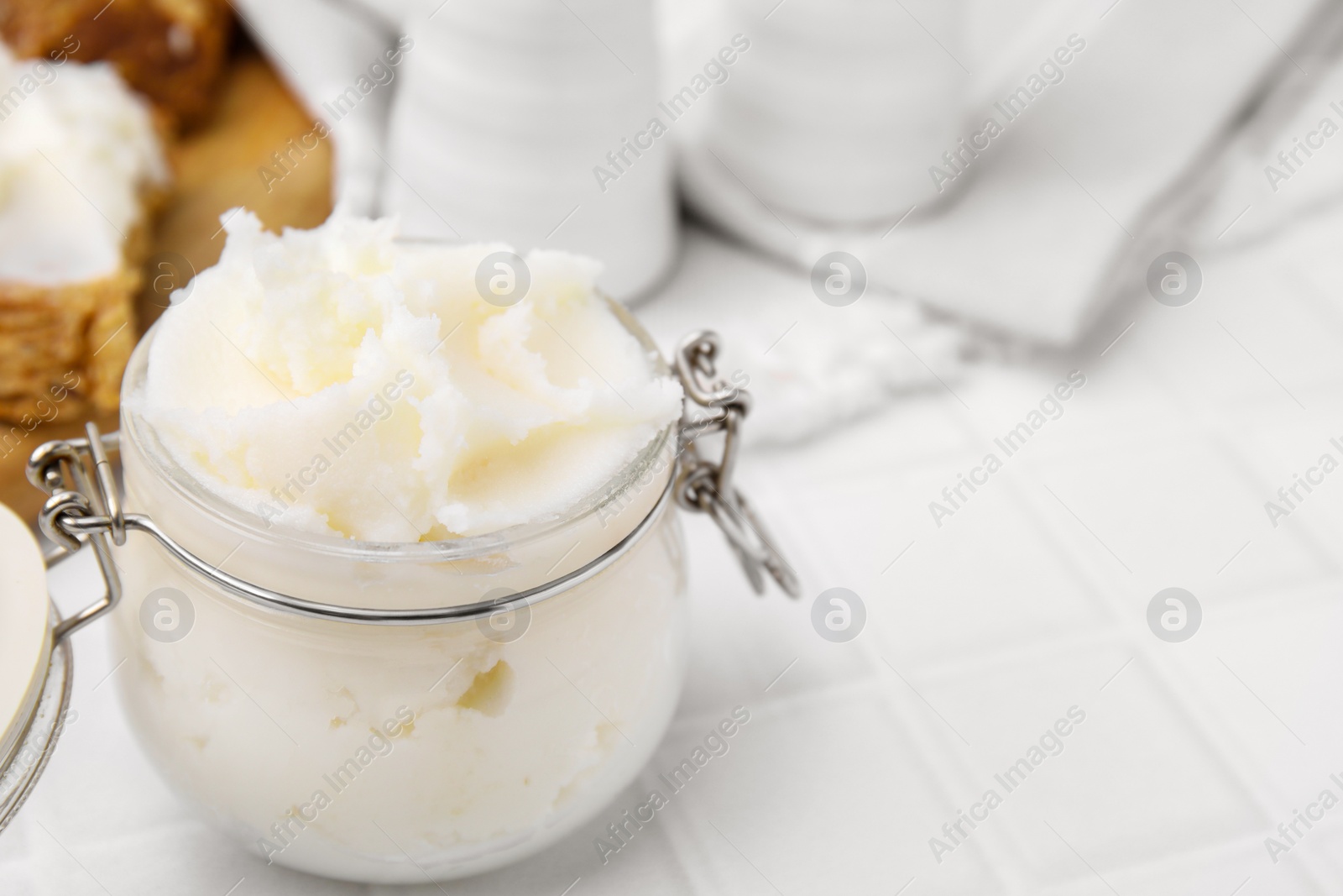 Photo of Delicious pork lard in glass jar on white table, closeup. Space for text
