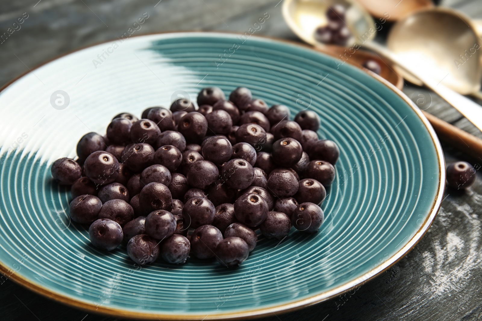 Photo of Plate with fresh acai berries on table, closeup