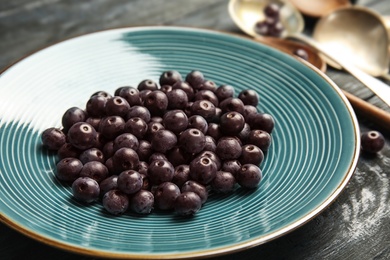 Photo of Plate with fresh acai berries on table, closeup