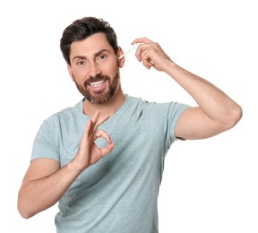 Photo of Man using ear spray and showing ok gesture on white background