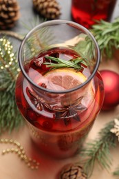 Photo of Glass bottle of aromatic punch drink and Christmas decor on table, above view