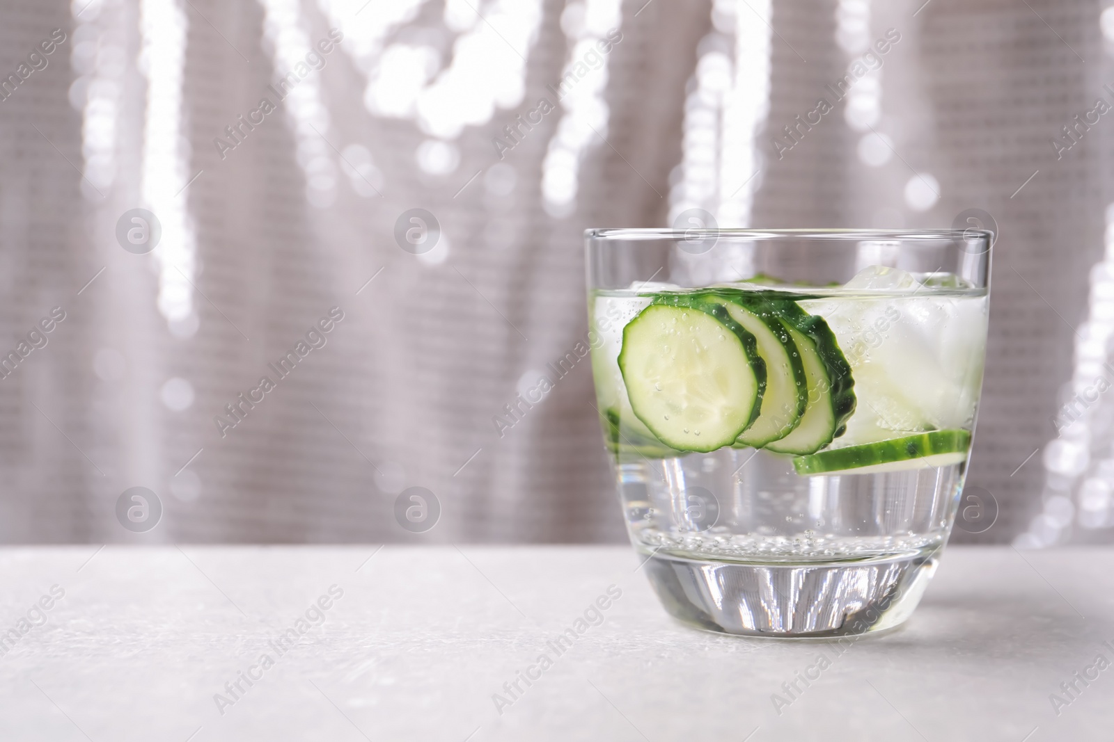 Photo of Glass of fresh cucumber water on table. Space for text