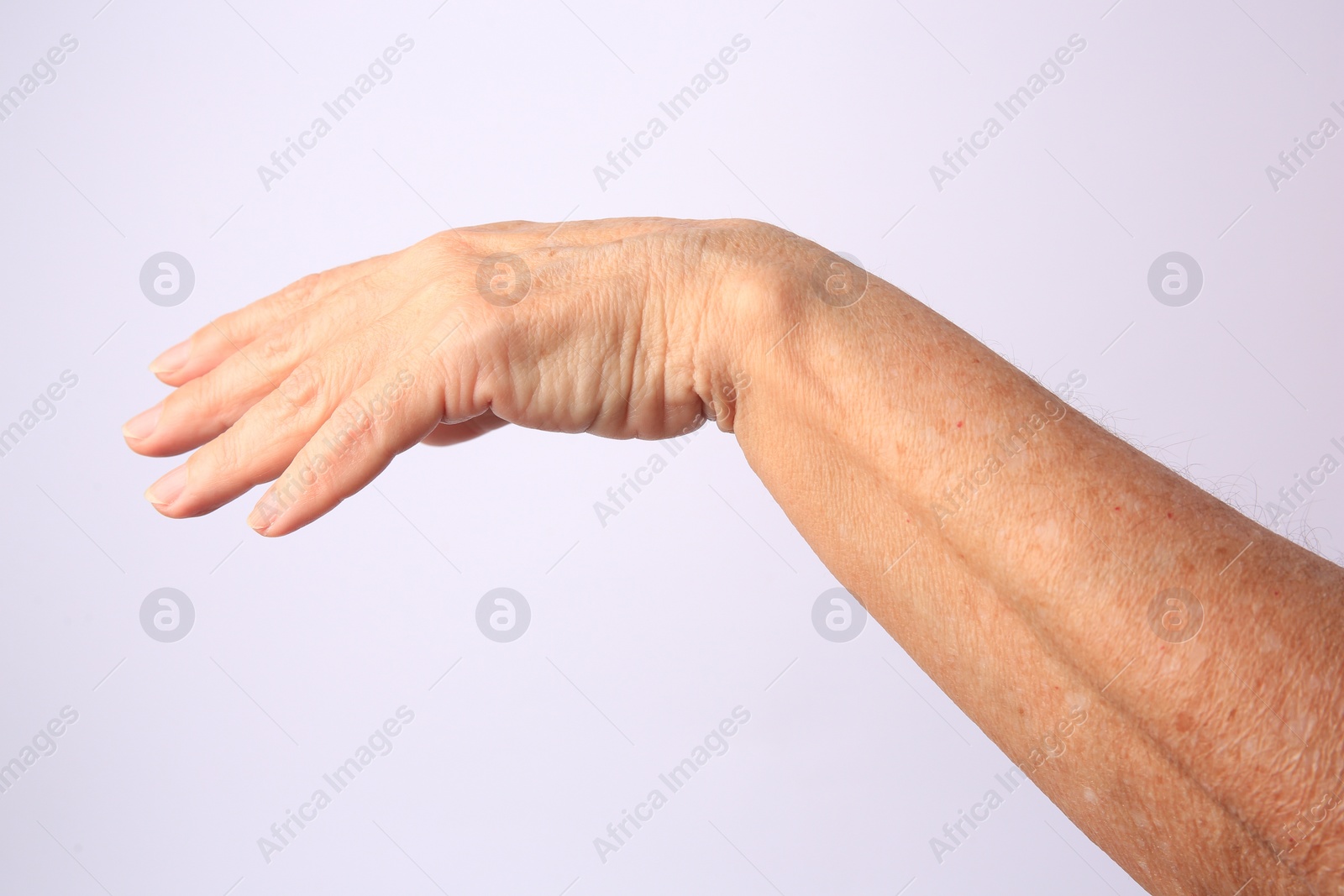 Photo of Closeup view of older woman's hand on white background