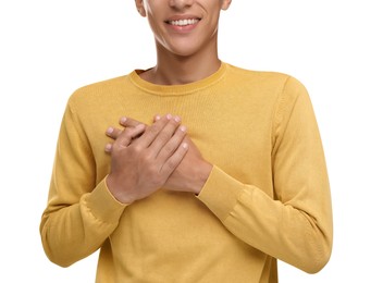 Photo of Thank you gesture. Grateful man with hands on chest against white background, closeup