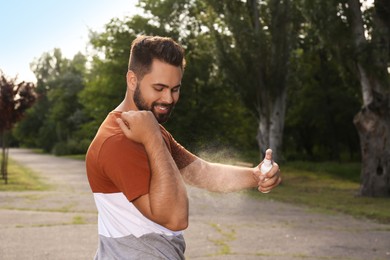 Man applying insect repellent on arm in park. Tick bites prevention