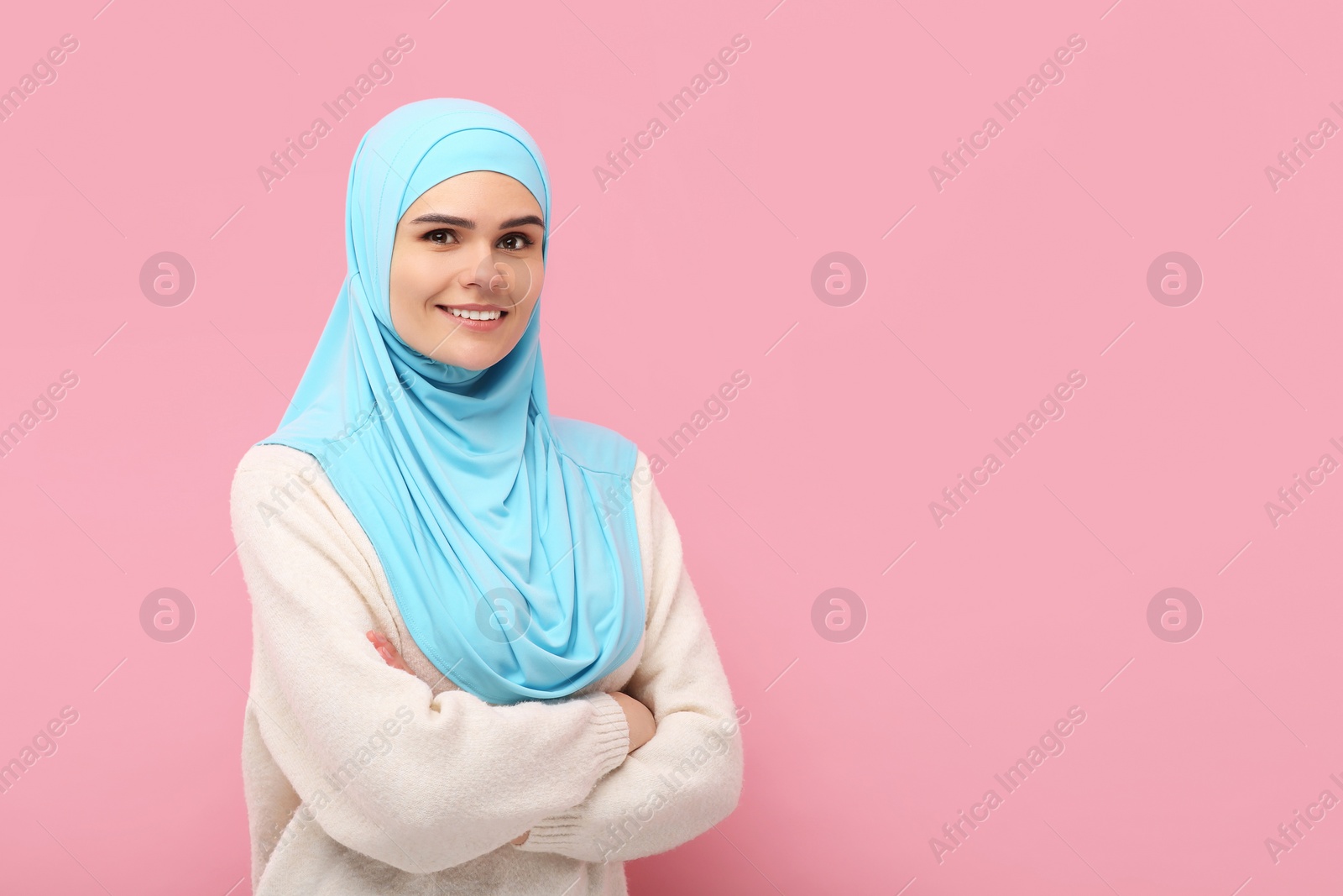 Photo of Portrait of Muslim woman in hijab on pink background, space for text