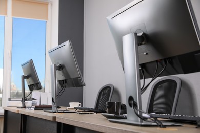 Open office interior. Modern workplaces with computers near light grey wall