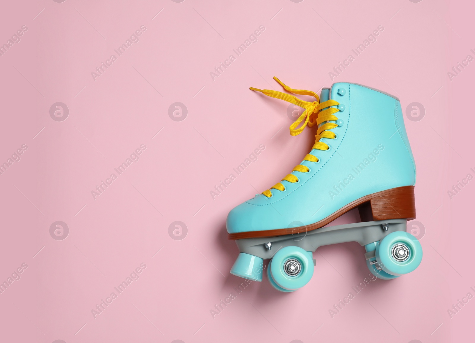 Photo of Stylish quad roller skate on color background, top view