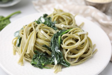 Photo of Tasty pasta with spinach and sauce on white table, closeup