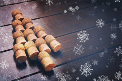 Image of Christmas tree made of wine corks on wooden table. Space for text