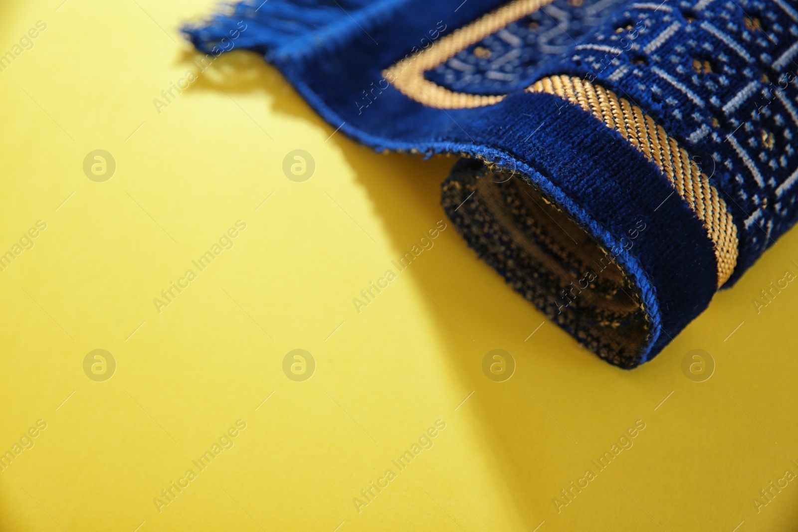 Photo of Muslim prayer rug and space for text on color background