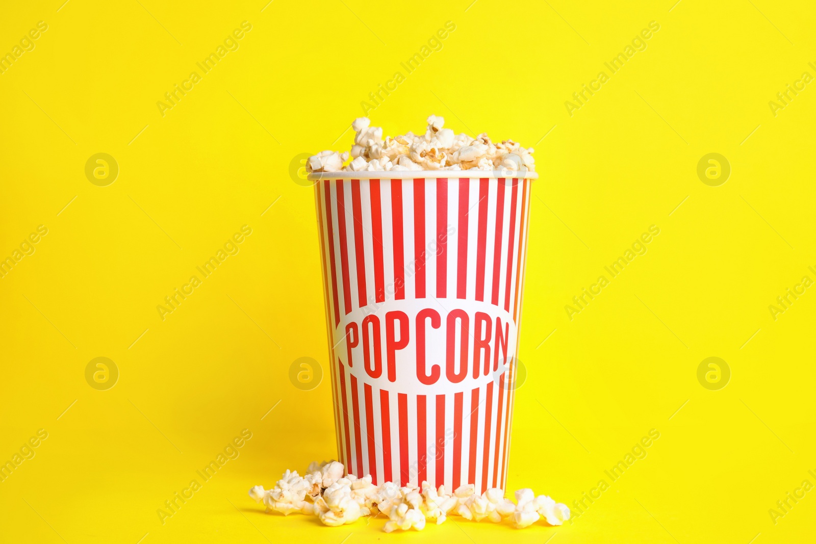 Photo of Tasty fresh pop corn on yellow background