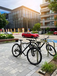 Photo of Beautiful view of modern buildings, bicycle stands and cars on city street