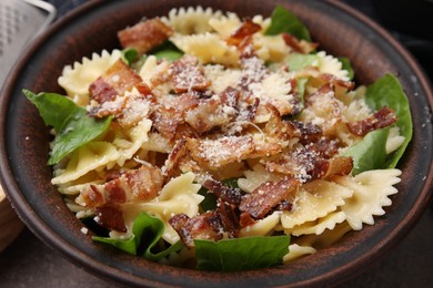 Photo of Tasty pasta with bacon and basil on brown table, closeup