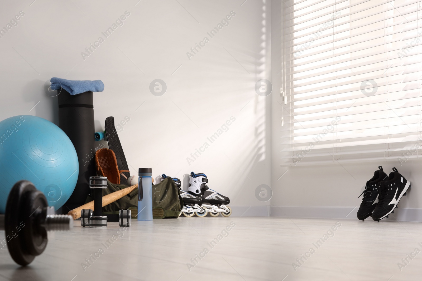 Photo of Many different sports equipment near wall indoors, space for text