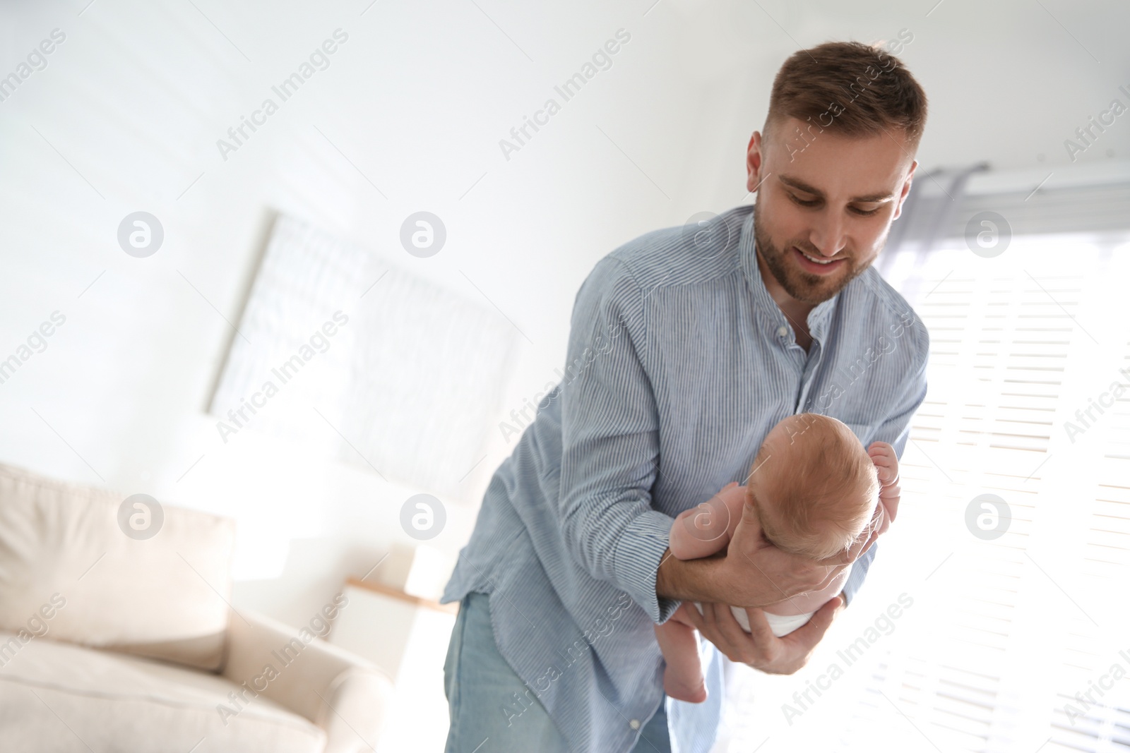 Photo of Father with his newborn son at home. Space for text