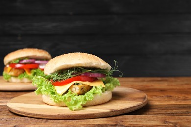 Delicious burgers with tofu and fresh vegetables on wooden table. Space for text
