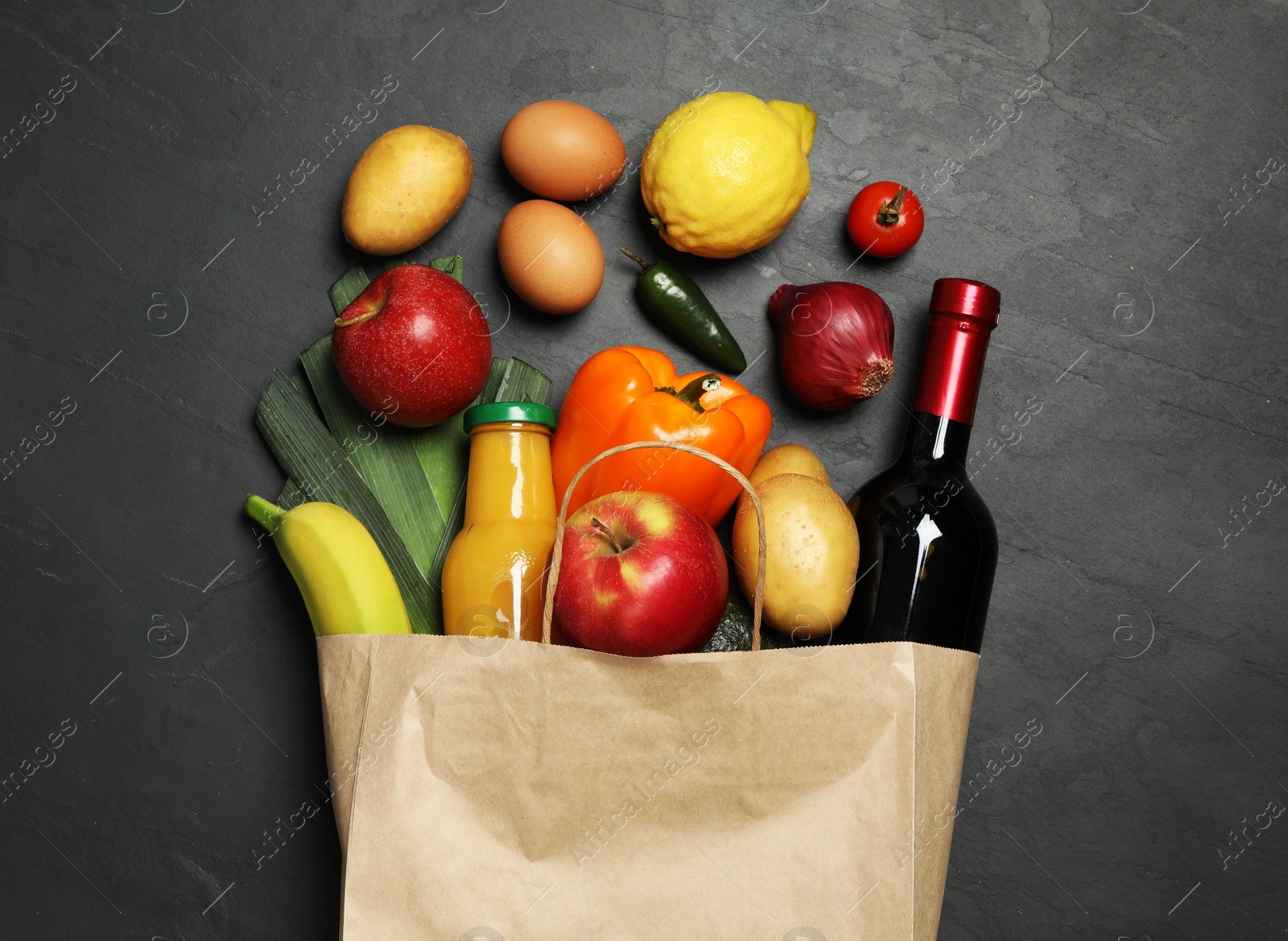 Photo of Paper bag with groceries on grey background, flat lay