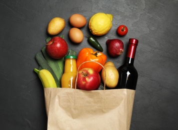 Photo of Paper bag with groceries on grey background, flat lay