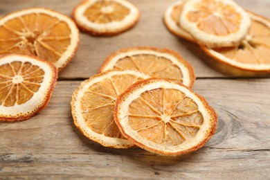 Photo of Pile of dry orange slices on wooden table