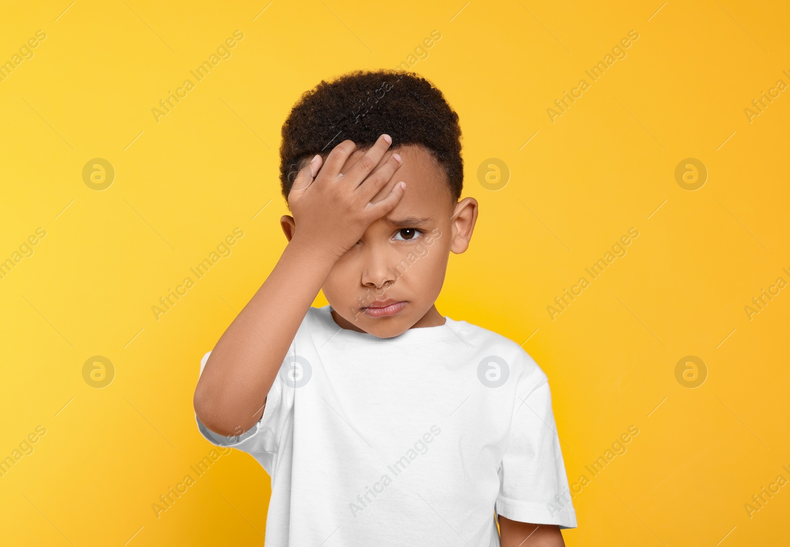 Photo of Portrait of emotional African-American boy on yellow background