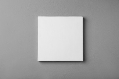 Photo of Blank canvas on grey wall. Space for design