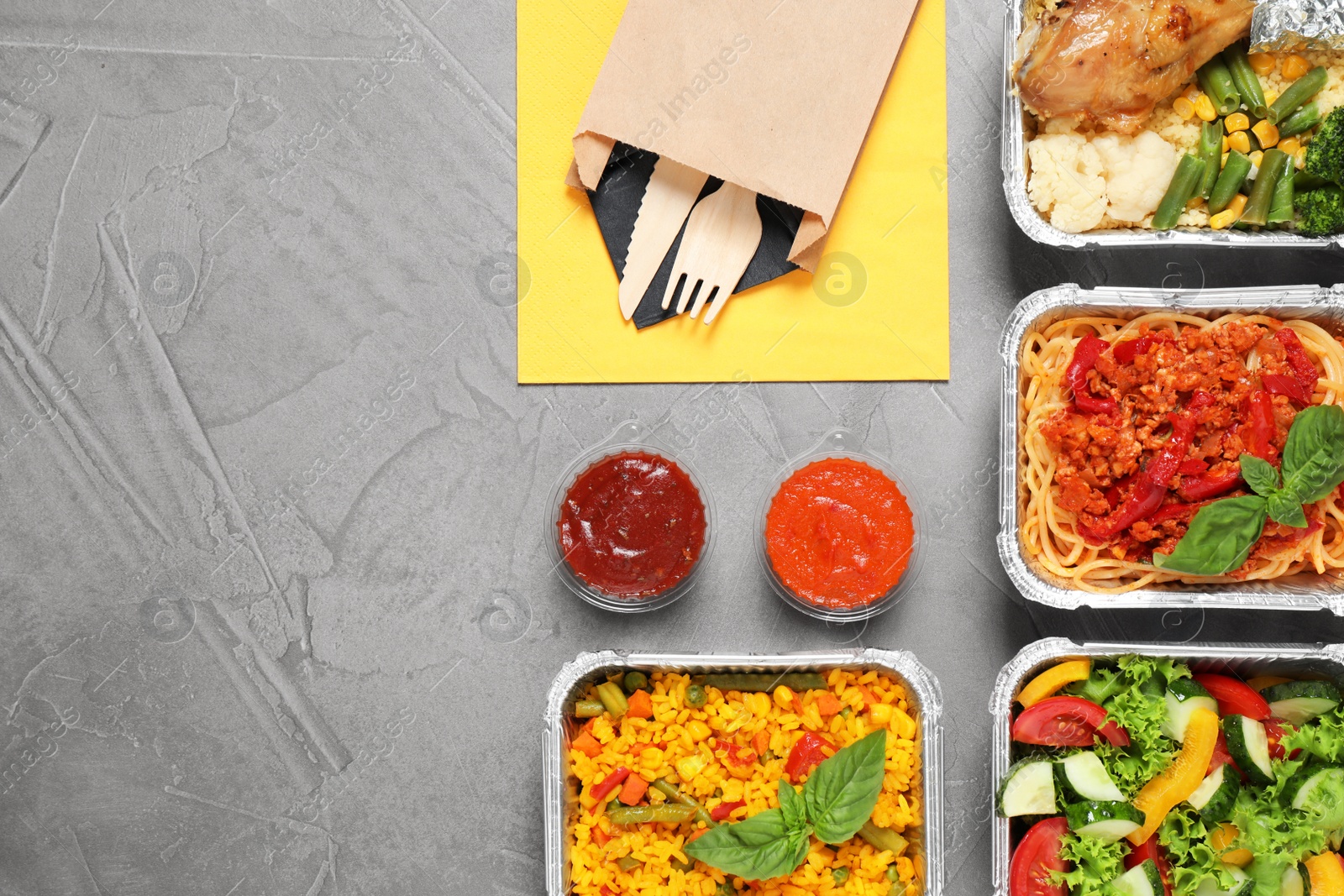 Photo of Lunchboxes on grey table, flat lay. Healthy food delivery