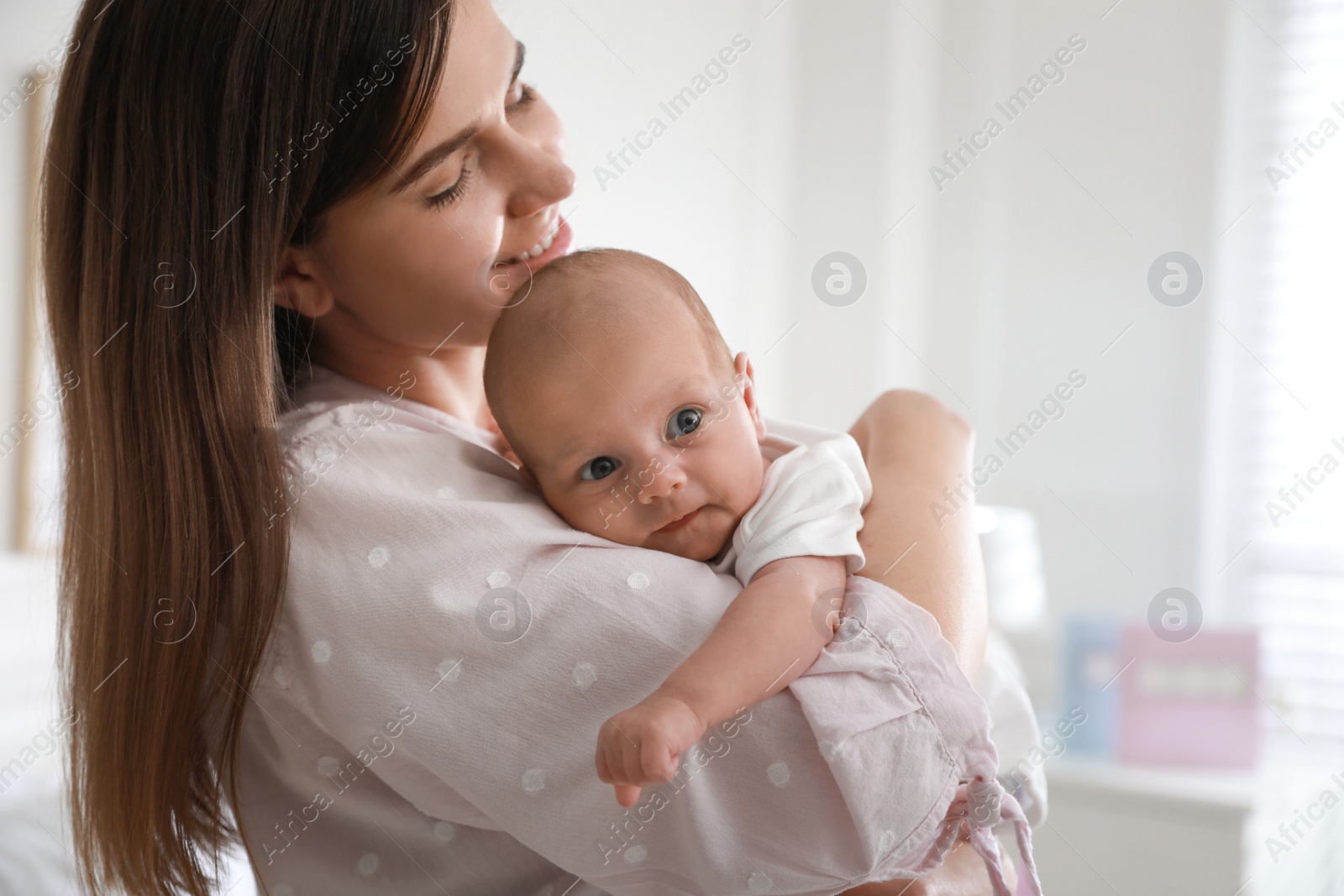 Photo of Mother with her newborn baby at home. Space for text