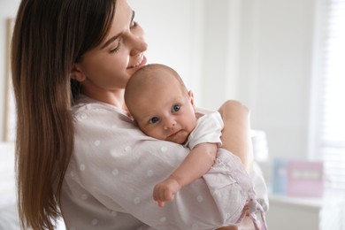 Mother with her newborn baby at home. Space for text